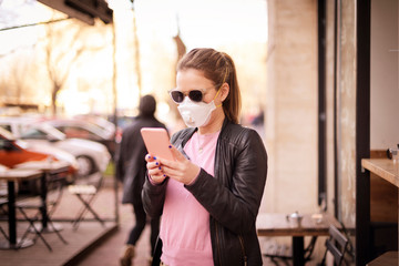 Young woman wearing a respirator mask on the street during the coronavirus outbreak