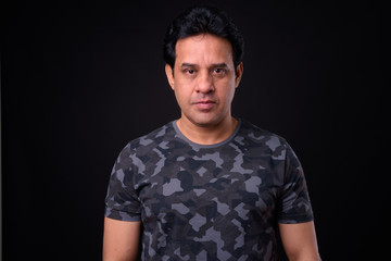 Obraz premium Mature handsome Indian man against black background