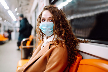 Girl in protective sterile medical mask in the subway car. Woman, wear face mask, protect from...
