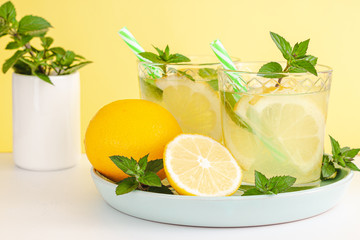 Lemon lemonade in mason jar glass ofwith lemons and straw on tab