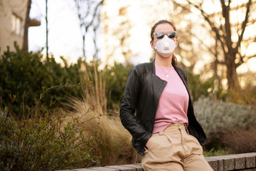 Shot of young woman wearing a respirator mask device while on the street