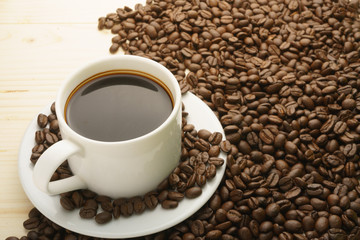 coffee cup with coffee beans on wooden table. free copy space for your text