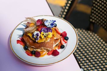 Pancakes with berries and edible flowers