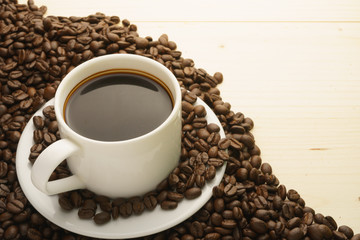 coffee cup with coffee beans on wooden table. free copy space for your text