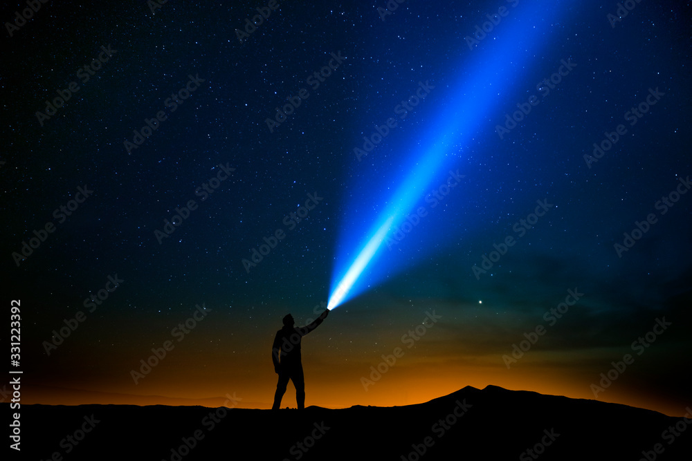 Sticker man with flashlight pointed at the starry sky