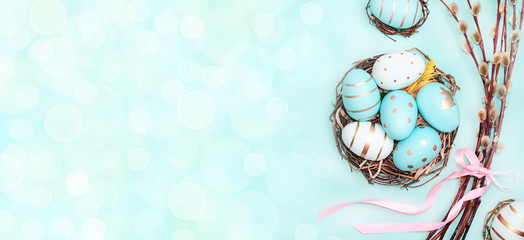 Easter background with Easter eggs in bird nest on blue background