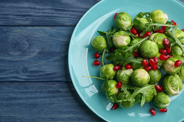 Tasty salad with Brussels sprouts on wooden table, top view. Space for text