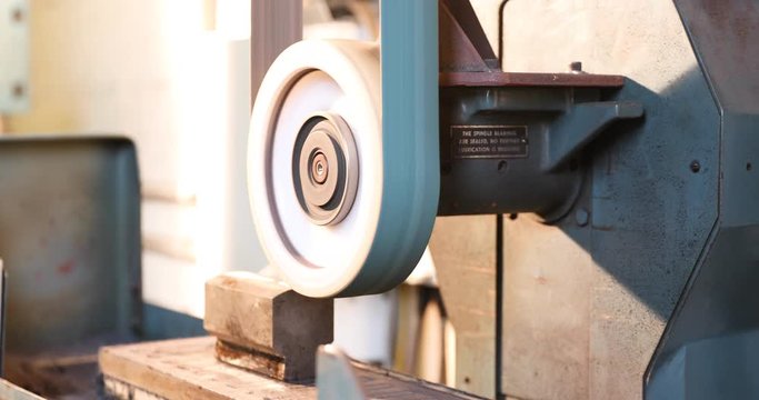 Belt grinder grinding a piece of steel
