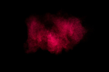 Red and pink powder explosion on black background. Colored powder cloud. Colorful dust explode. Paint Holi.