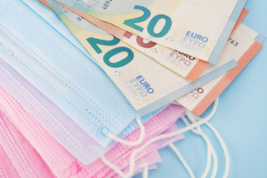 Medical blue, pink masks and euro money.Soft focus.Close up.Concept of expensive purchase, deficit, protection against viruses, diseases.