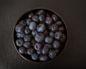 A studio photograph of a bowl of blueberries