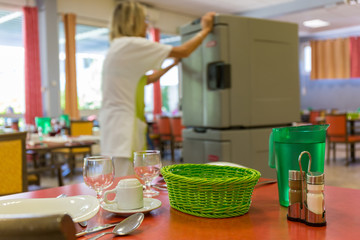Femme agent de service en maison de retraite avec chariot repas en salle restaurant