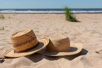 View of a sandy beach with summer hats. Blank advertisement or packaging layout.