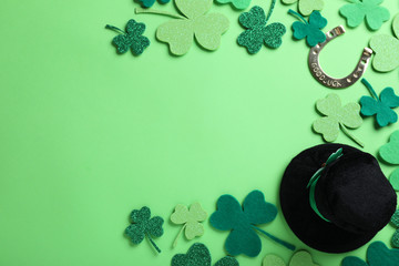 Flat lay composition with leprechaun hat on light green background, space for text. St. Patrick's...