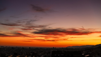 Lindo por do sol com céu amarelo e laranja em um mirante na cidade de Barcelona, Espanha