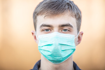 Young man with protective mask on his face. Protection against virus dust or smog. Coronavirus Covid-19 concept