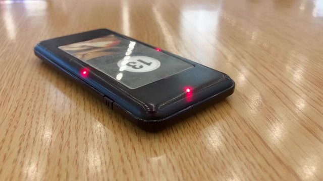 Pager on table vibrates and blinks, signaling to pickup the order
