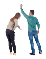 Back view of couple in sweater pointing.