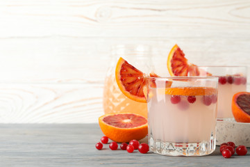 Lemonade, red orange and cranberry on wooden background, space for text