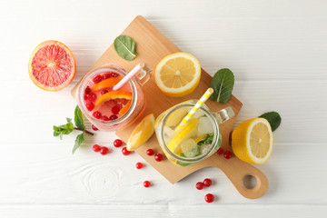 Glass jars with lemonade on wooden background. Fresh drink