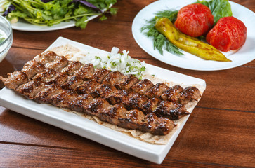 Fast food. Eastern food. Shish kebab, lyulya-kebab. Dishes of oriental cuisine lying in plte and...