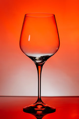 Empty wine glass on a red background.
