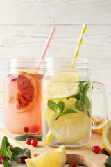 Fototapeta na wymiar Glass jars with lemonade on wooden background. Fresh drink