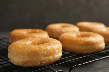 Sweet delicious glazed donuts on grey table