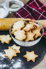 Biscuits sablés dans un bol, rouleau à patisserie farine et  forme en métal à découper