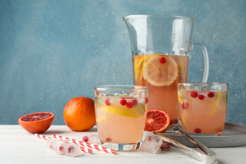Lemonade with cranberry and lemon on wooden background, space for text