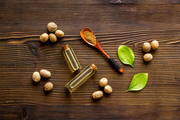 Nutmeg oil - perfume ingredient - on wooden background top-down