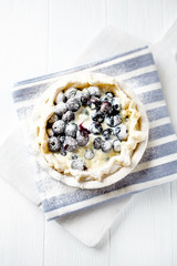 Blueberry Quiche ina Ceramic Dish on white wooden background. Top view.