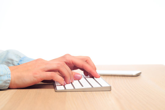 female hands type on a modern wireless keyboard on Office table  - Image