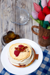 Dessert Pavlova with raspberries, on old wooden table. Dessert Pavlova and figs and tulips on a rustic background.