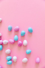 Colorful easter eggs on pink pastel color background with space.