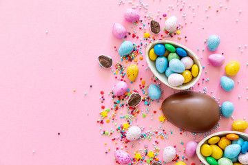 Chocolate Easter eggs with multi-colored candy decorations. Copy space