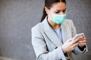 Pretty young woman with protective facial mask on the street