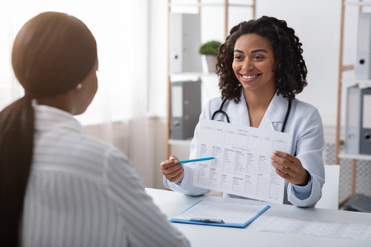 Cheerful Lady Dietologist Showing Patient Treatment Plan While Consultation