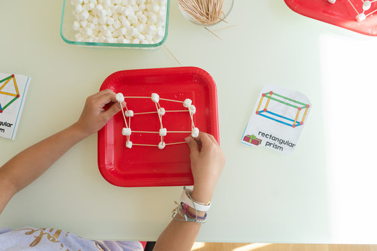 Directly above view of young child building a three dimensional rectangular prism as part of a homeschool STEM lesson