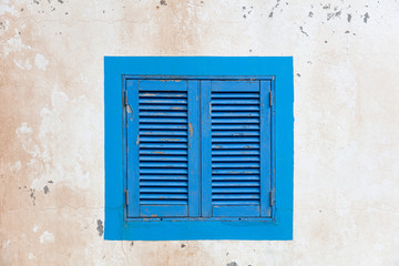 Vintage blue window shutter on the old house