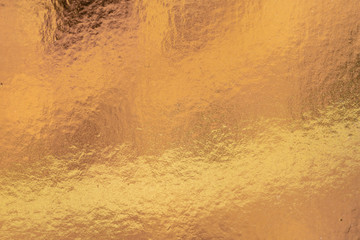 Metalic gold color, shiny reflective textured background