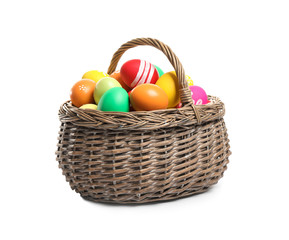 Bright Easter eggs in wicker basket isolated on white background