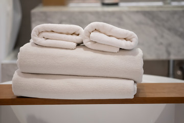 White bath towels are stacked on shelf