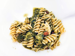Pasta with pesto sauce and nuts on a the table