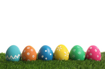 Colorful Easter eggs in green grass on white background