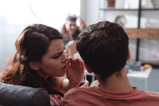 Selective Focus Of Man In King Costume Near Girl Whispering To Friend