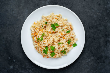 Bulgur with vegetables on a stone background. Healthy eating