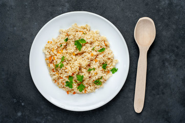 Bulgur with vegetables on a stone background. Healthy eating