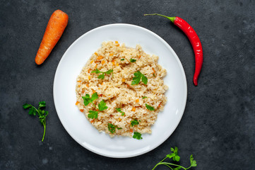 Bulgur with vegetables on a stone background. Healthy eating