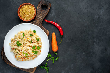  Bulgur with vegetables on a stone background with copy space for your  text. Healthy eating
